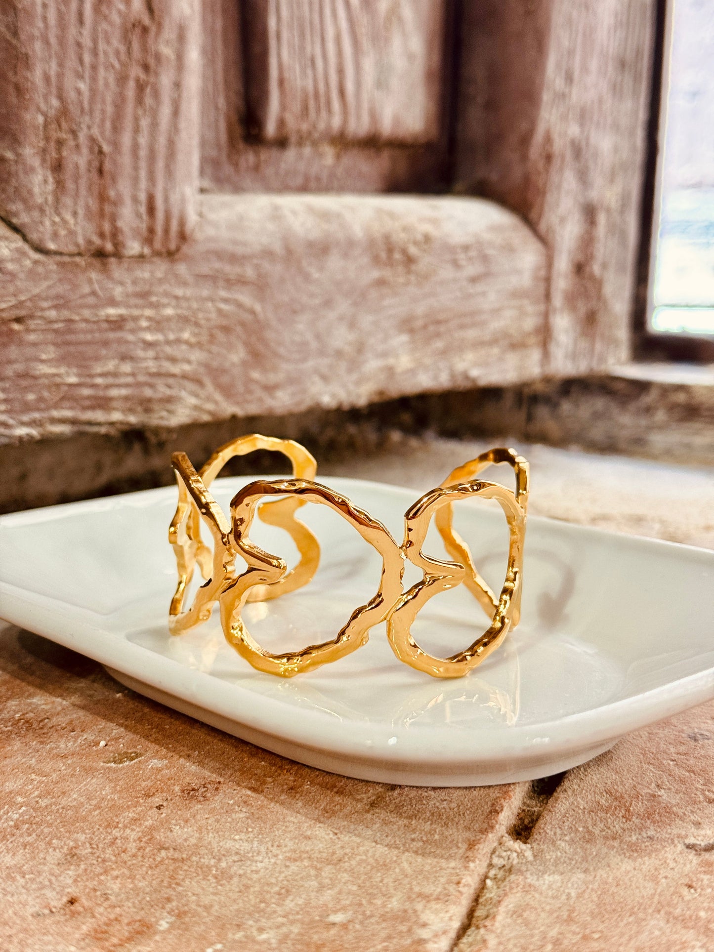 Brazalete de acero inoxidable dorado – Corazones entrelazados Les Trouvailles de Tolède